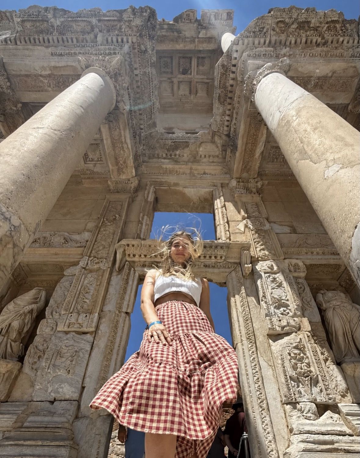 Traveller with walking shoes and a sun hat exploring ancient marble ruins in Turkey